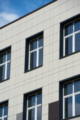 facade of a modern building on a bright Sunny day, siding and Windows, beautiful exterior of the new building