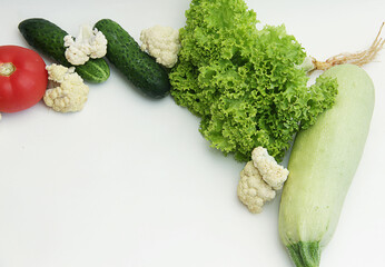 fresh vegetables close-up tomatoes, cucumbers, lettuce, cauliflower, zucchini lie in a circle in the center of the vegetables sign with advertising or text