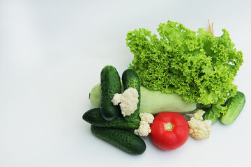 fresh different vegetables tomatoes, cucumbers, lettuce, cauliflower, zucchini on a white background