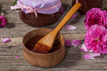 Fototapeta na wymiar Homemade tea rose petal jam on a old wooden table