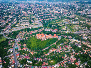 Aerial view of medieval castle Palanok, Mukachevo (Munkacs), Transcarpathia (Zakarpattia), Ukraine. Summer landscape with old architecture, green trees and town, outdoor travel background