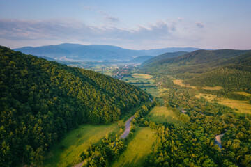Aerial view of the beautiful wooded Carpathian mountains and small village, summer landscape, outdoor travel background, Transcarpathia (Zakarpattia), Ukraine