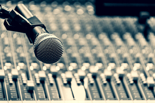 dynamic microphone on audio mixing console background in broadcasting studio
