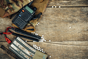 Close up of airsoft gun magazine and airsoft balls on wooden background