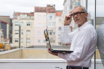 mature man with glasses using laptop