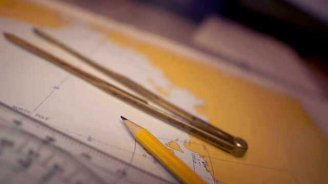 Plotting position on navigational chart at sea. Marine Map and ruler. Sowmotion shot