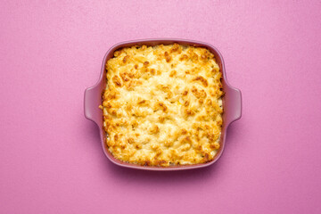 Mac and cheese oven-baked, top view. Macaroni with bechamel sauce in a pink tray