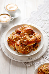 Homemade yeast croissants with cinnamon and walnuts on a white plate  close up view