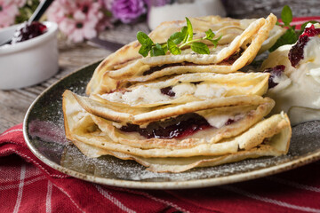 Crepes with ricotta cheese and blackcurrant jam.