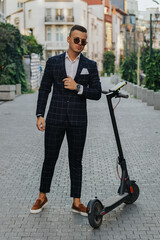 Young bussinesman with electric scooter posing during work break.