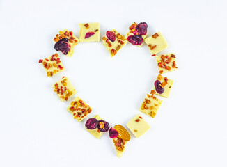 White chocolate with dried berries, fruits and almonds in the shape of a heart.