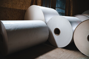 Big Stack of Printing Paper Rolls in Warehouse. The concept of production of paper and paperboard....