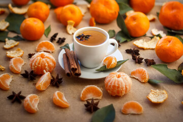 Beautiful still life. Close-up.  cup of coffee, tangerines and cinnamon Peeled Tangerine orange and Tangerine orange slices on a Dark Background. Citrus background, Top view.