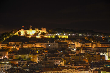 Night view of old town and Sao Jorge Castle from Sao Pedro de Alcantara viewpoint (miradouro), in Lisbon, Portugal