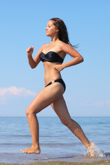 Fototapeta premium Woman in bikini run on beach