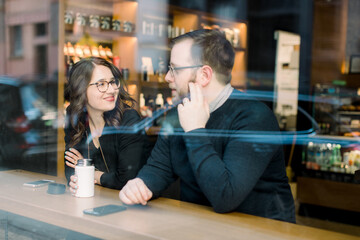 A young heterosexual couple enjoying a conversation at a nyc coffee shop