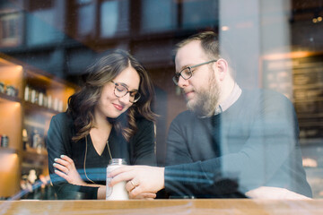 A young heterosexual couple enjoying a conversation at a nyc coffee shop