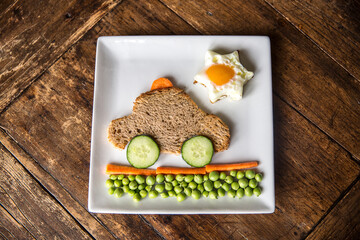 Creative and healthy kids meal, cute taxi car  made from toasted bread, sun from egg and tasty...
