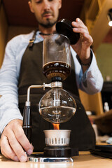 Syphon coffee brewing process. Close up syphon is heating by fire. Brewing photo on the fire....