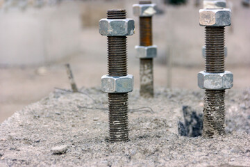 View of the the anchor bolts and nuts in the concrete foundation in the new industrial plant.