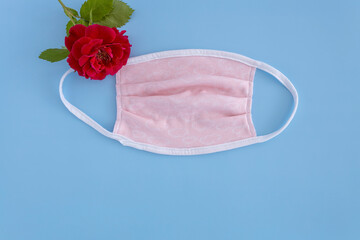 medical protective mask and rose on a blue background