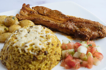 Rice with lentils, baked pork ribs, boiled potatoes, and tomato cucumber salad. Arroz moro.