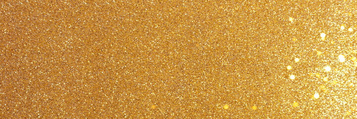 Golden glitter texture background with glowing bokeh. Shiny festive banner.