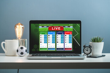 Front view of laptop with bookmaker's website interface design template on its screen, standing on...