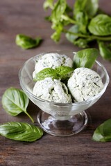 Homemade basil ice cream with fresh basil on a dark background. Copy space