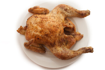 isolated roasted chicken in a white plate on white background view from above
