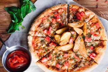 Appetizing pizza on a wooden table surrounded by herbs and spices. The concept of delicious food, restaurants and cafes