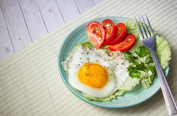 fried egg with tomatoes and parsley on wooden background