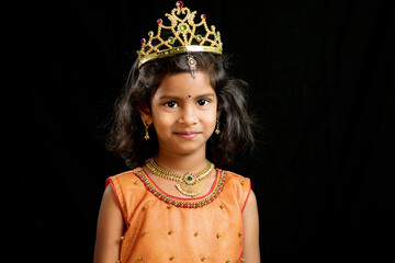 Happy little girl child wearing princess gown and golden crown smiling