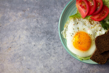 fried egg with tomatoes on marble rock background