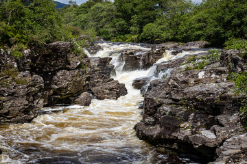 Long exposure shot of the waterfalls in Glen Orchy near Bridge of Orchy in the Argyll region of the highlands of Scotland during summer whilst the river is flowing fast from rainfall