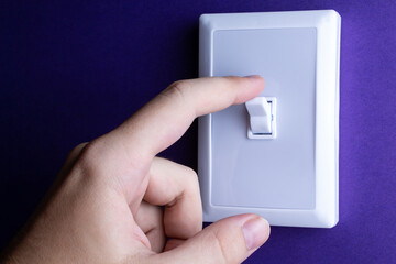 Man switches the switch to the lower position on a blue background