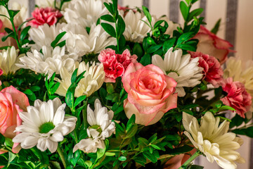 Bouquet of flowers in a box given to any wife for the anniversary. Bunch of flowers of roses, daisies and greenery in a decorative paper cylinder. Close up.