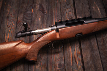 bolt action rifle on a wooden shield