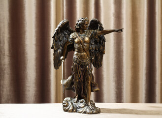 Statuette of the Archangel Michael on a velour background.