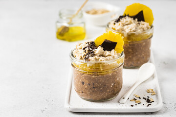 Pumpkin citrus fall cocoa overnight oats in glasses.  Selective focus, copy space.