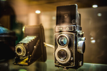 Two old cameras exposed in glass.