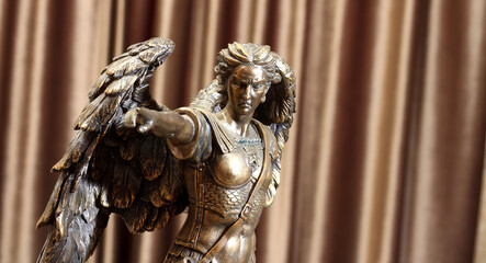 Fototapeta na wymiar Statuette of the Archangel Michael on a velour background.