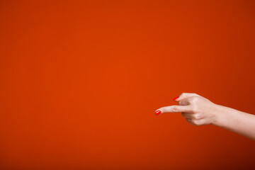 Female hands showing middle fingers to the camera. Aggressive provocative gestures on an orange...