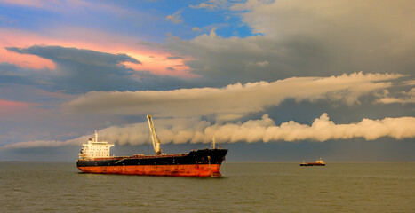 Bulk carrier vessel is awaiting loading of bauxite ore at outer anchorage of Kamsar port, Guinea,...
