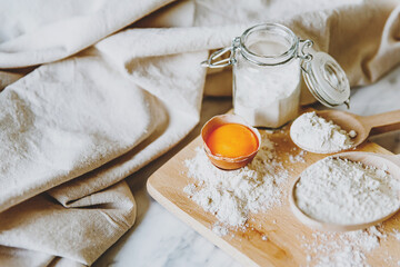 Baking ingredients with eggs, wheat flour, egg yolks for pastry. Cake, pasta or dough recipe ingredients. Top view on table