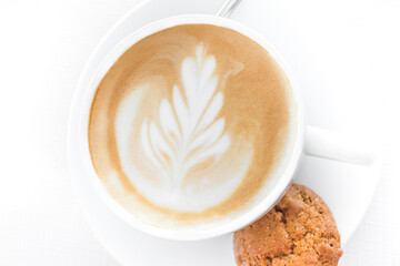 White coffee cup with a single cookie