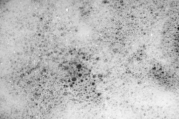 Fototapeta na wymiar White foam on black background. Foam bubble from soap or shampoo washing on top view. Foam background. White foam.