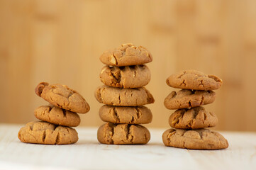 Very tasty peanut butter biscuits on bamboo light brown wooden board, golden baked healthy