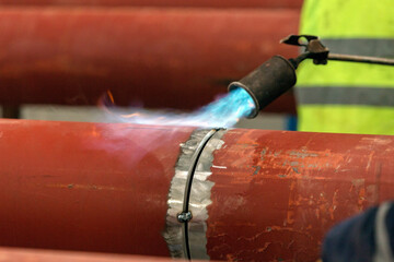 The welder is preheating to pipeline before welding. The phenomenon of heating the joint in the...