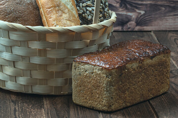 rectangular loaf of wheat bread with a baked shiny crust on the kitchen table.